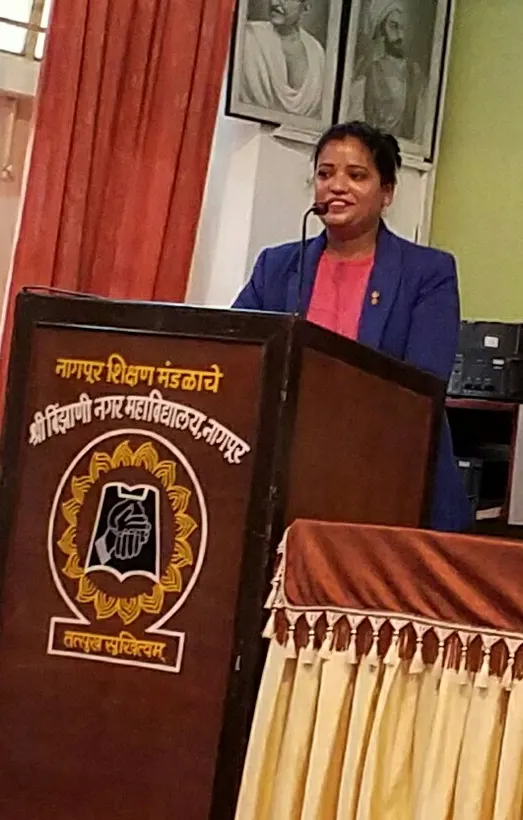 Dr. Abha Jain speaking at a college podium in Nagpur